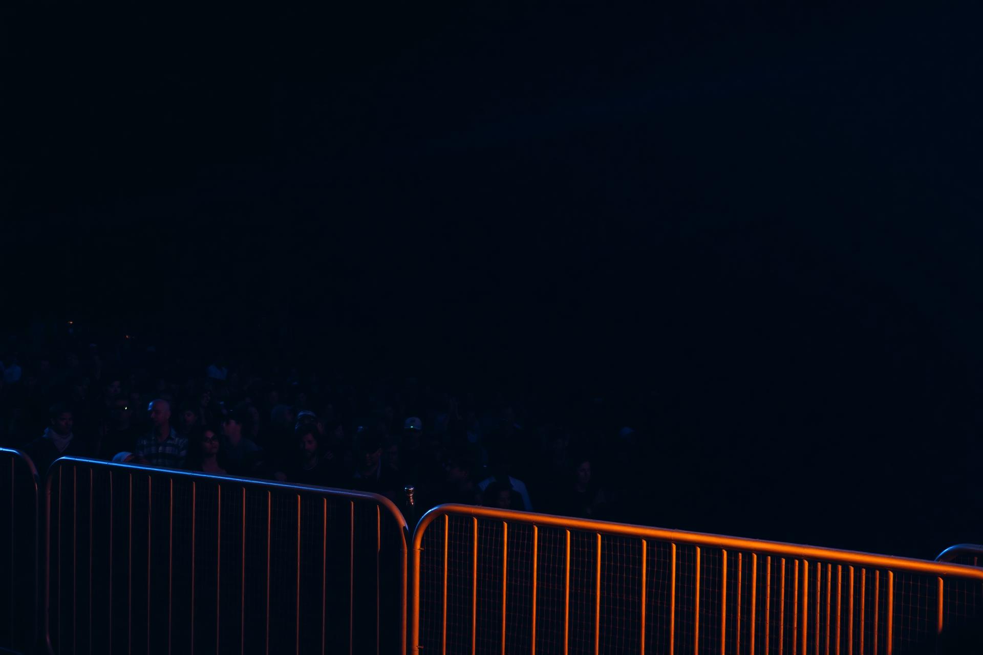 Crowd protected by security barriers at a night event